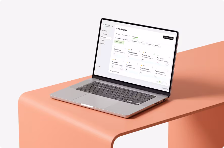 Laptop showing the Bella flashcards dashboard on a coral desk