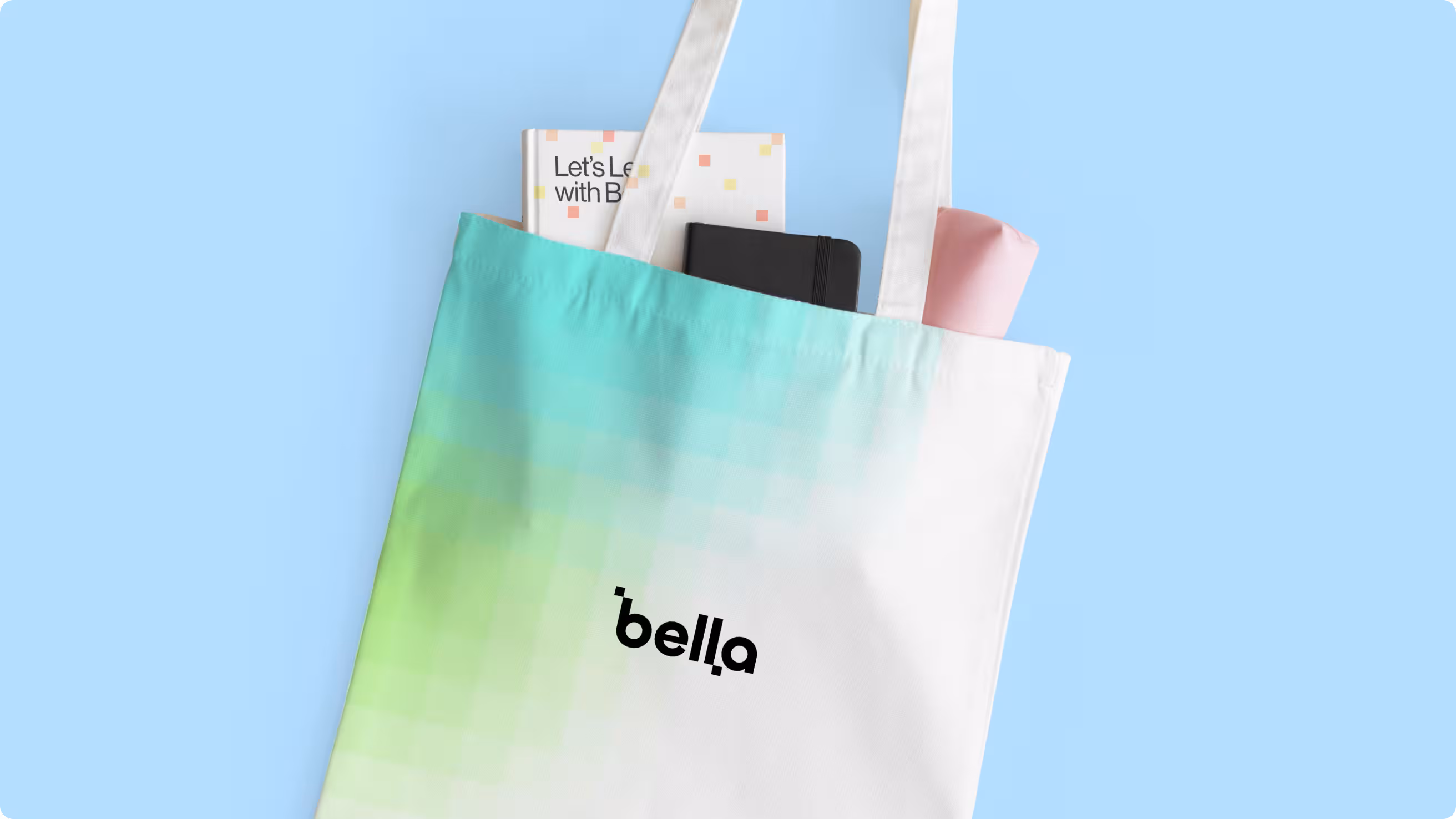Gradient tote bag with the Bella logo and a Let's Learn with Bella notebook