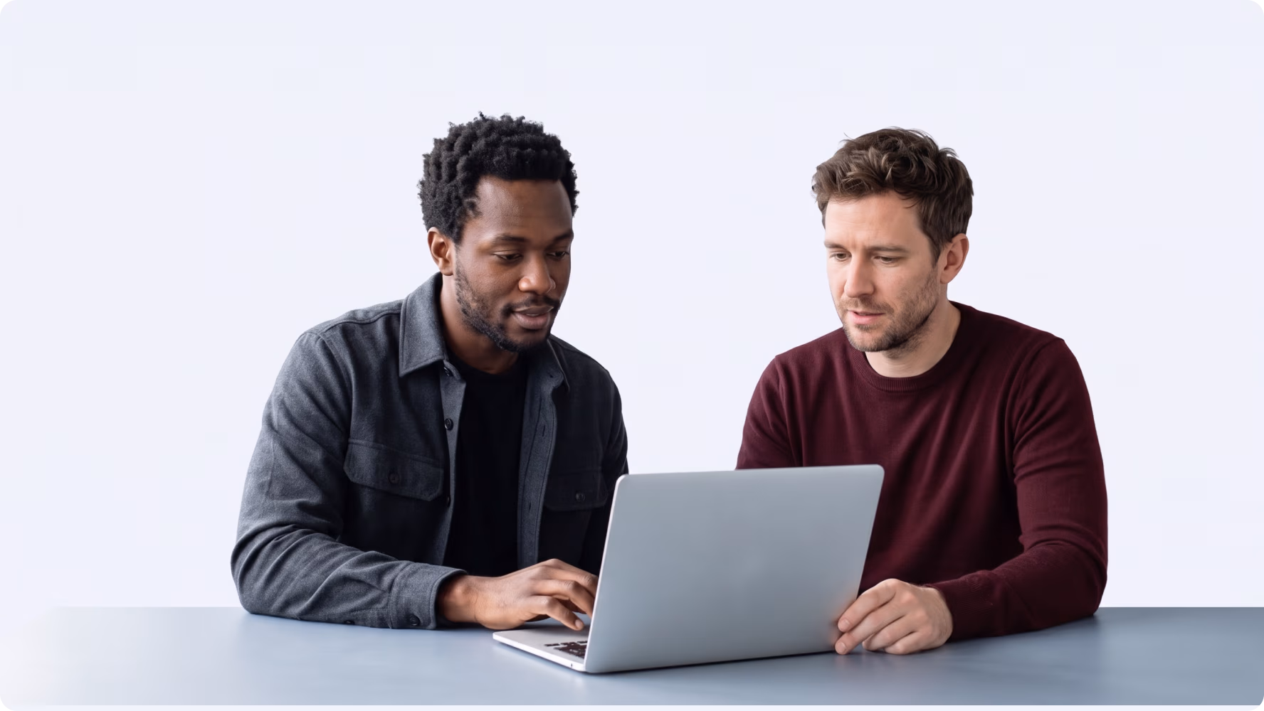 Two developers reviewing the RedPath platform codebase on a laptop