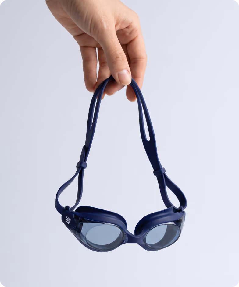 Swim goggles held over a white background