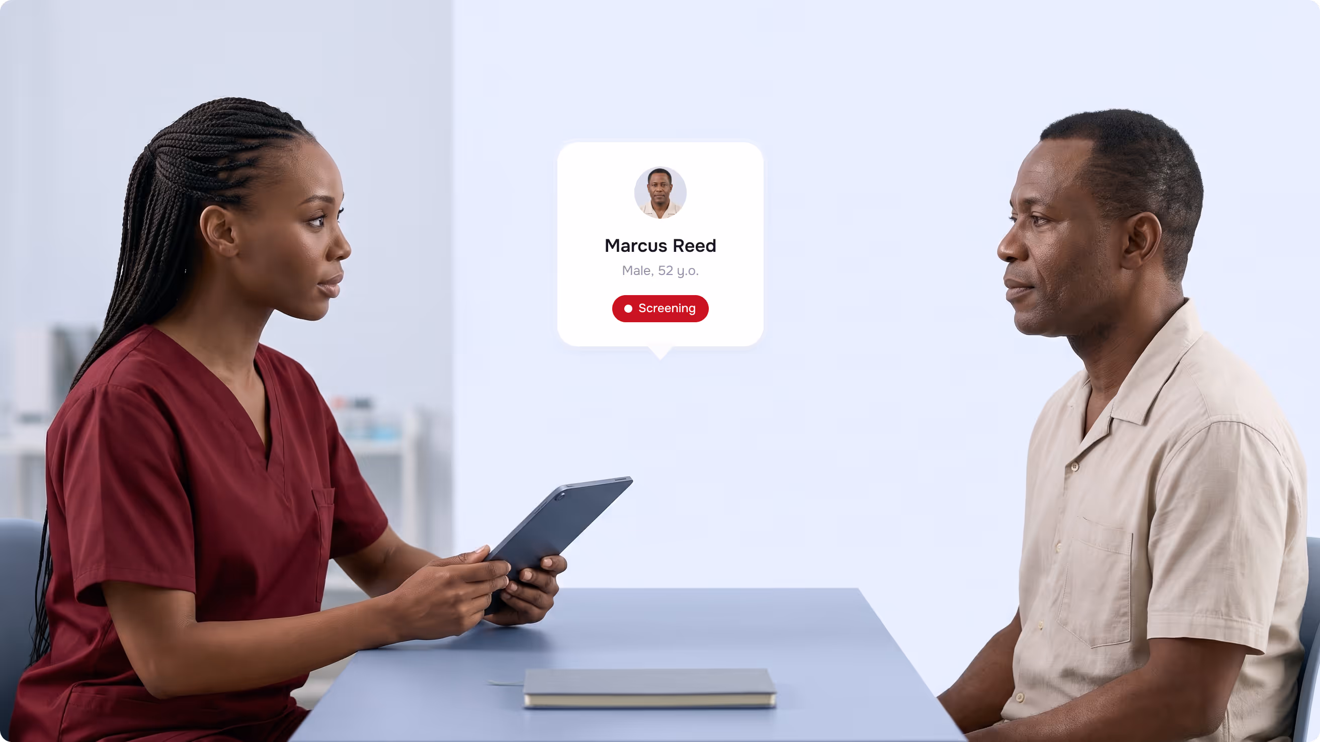 Patient navigator with a tablet talking to a patient, his screening status shown on a card between them